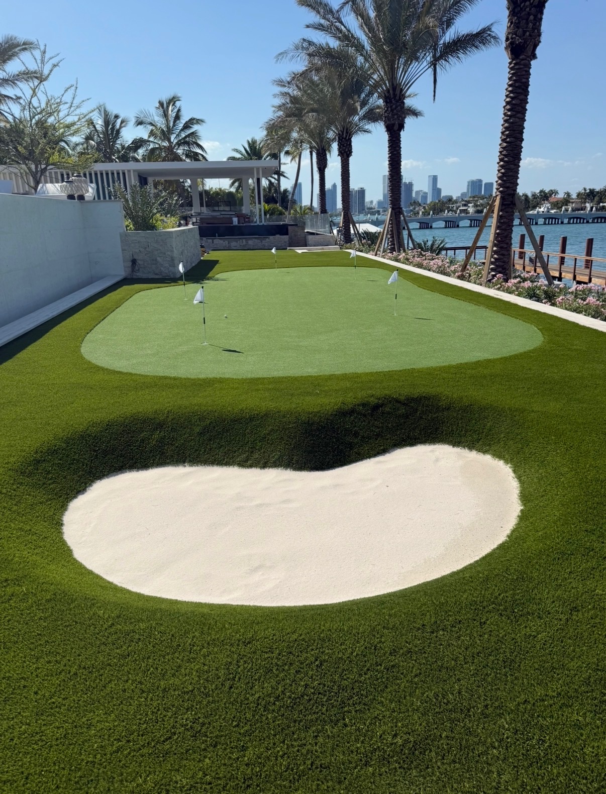 Artificial putting green with sand bunker and turf lawn